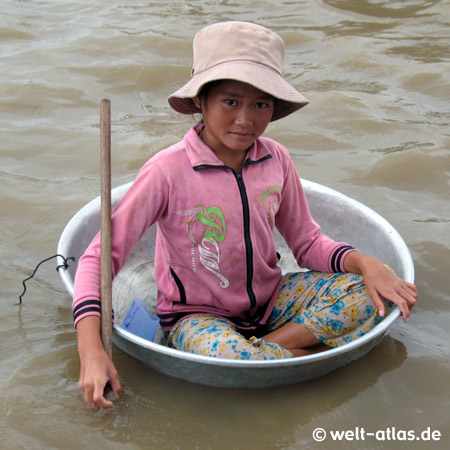 Lake Tonle Sap, young girl sittingin a wash bowl