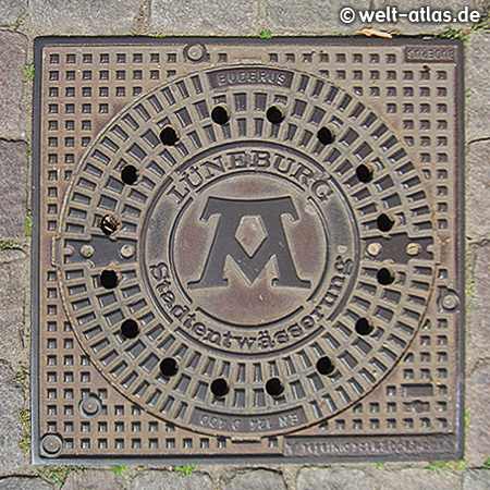 Sieldeckel, Kanaldeckel in Lüneburg – Stadtmarke mit dem Symbol für "mons, pons, fons" („Berg, Brücke, Quelle“) 