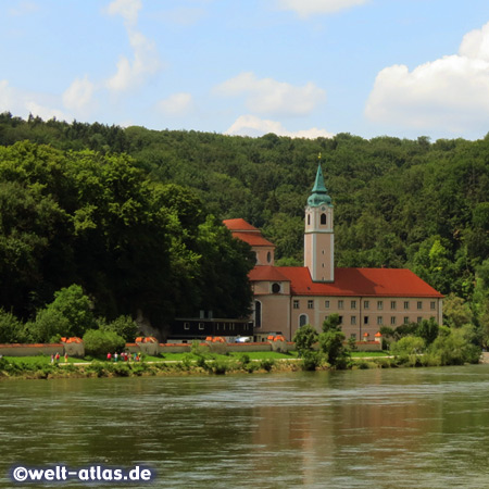 Blick vom Schiff auf das Ufer der Donau mit der Klosteranlage Weltenburg an einer Flussschleife nahe Kelheim