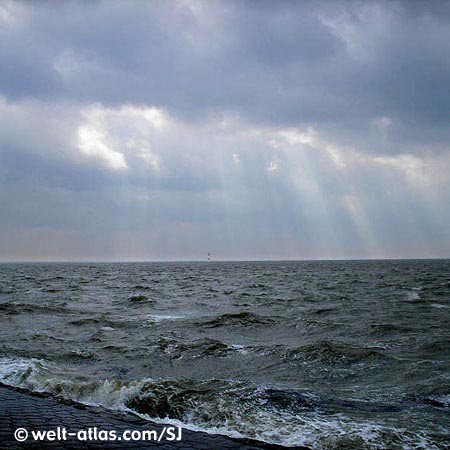 Aufgewühlte Nordsee bei Wilhelmshaven, Arngaster Leuchtturm in der Ferne