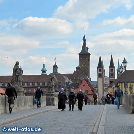 Auf der Alten Mainbrücke in Würzburg, dahinter die Türme von Rathaus und Dom