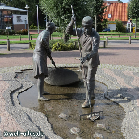 The bronze sculpture "Jan and Gret" at the market square in the village - Gret is collecting crabs, mussels and eels and Jan stabs the flatfish - St. Peter-Ording