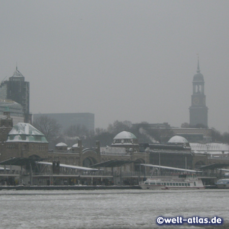 Die St. Pauli-Landungsbrücken an einem eisigen Wintertag, dahinter der Michel im Dunst, Hamburg