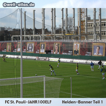 Ganz neu im Stadion am Millerntor: Helden-Banner mit der FC St. Pauli Jahr100Elf zum Jubiläumsjahr, vor der Baustelle der neuen Haupttribüne - Teil 1, linke Seite