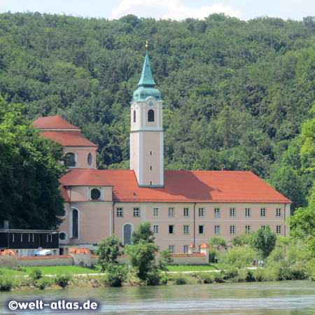 Blick vom Schiff auf das Ufer der Donau mit der Klosteranlage Weltenburg an einer Flussschleife unweit von Kelheim