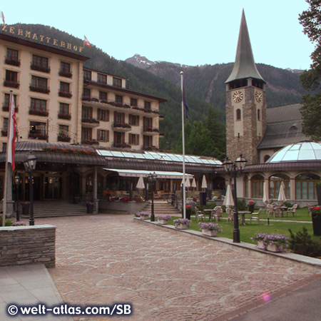 Das Grand Hotel Zermatterhof, daneben die Katholische Kirche, Zermatt, Wallis, Schweiz