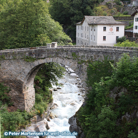 Old mill house at the stone bridge over the Maira/Mera in Promontogno near Bondo in Graubünden, Switzerland