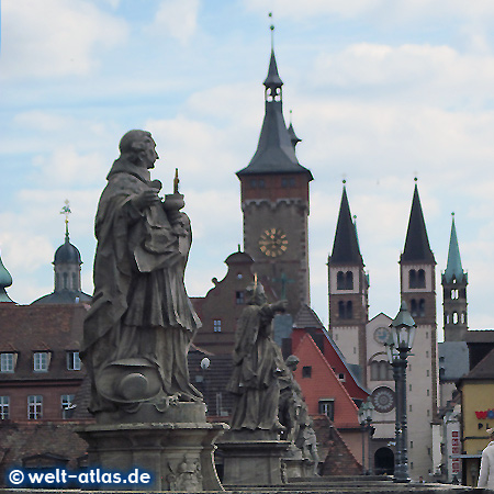 Brückenheilige auf der alten Mainbrücke in Würzburg, dahinter die Türme von Rathaus und Dom