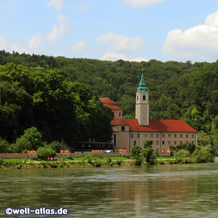 Blick vom Schiff auf das Ufer der Donau mit der Klosteranlage Weltenburg an einer Flussschleife unweit von Kelheim