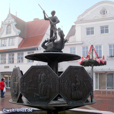 Brunnen auf dem Südermarkt in Heide mit der Figur des heiligen St. Georg, der den Drachen tötet und Relieftafeln zur Dithmarscher Geschichte.