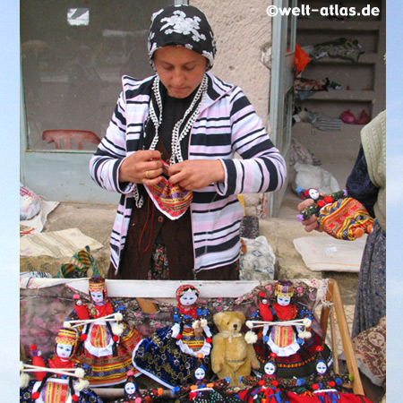Frau beim Nähen einer Soganli-Puppe, in der Tracht der Region 