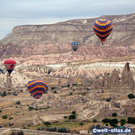 Heissluftballons vor der rosafarbenen Felswand des Aktepe