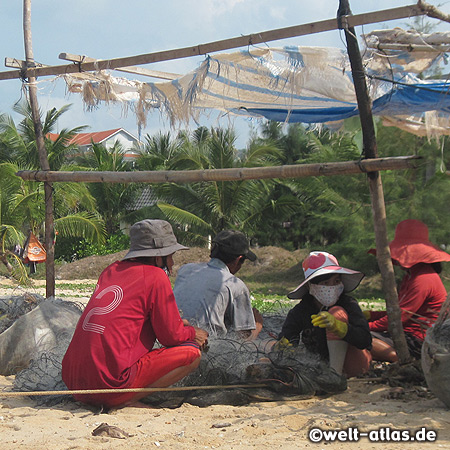 Fishermen repair their nets at the beach near Eden Resort Phu Quoc Island