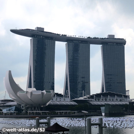 Impressive architecture - the Marina Bay Sands hotel at the Bayfront Avenue with the huge roof terrace, in the foreground, the ArtScience Museum