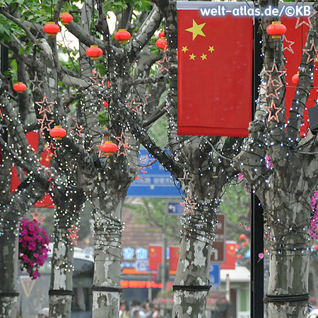 Red flags, lanterns and lights decorate the trees