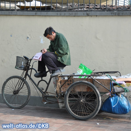 Kleine Pause - Mann mit Zeitung auf dem Fahrrad