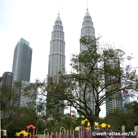 Blick vom Spielplatz im Park auf die Petronas Towers und weitere Wolkenkratzer in Kuala Lumpur