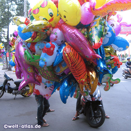 Luftballonverkäufer mit Trauben von Ballons, Tet-Feiertage in Saigon