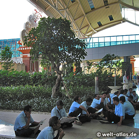 Arrival at the airport in Denpasar, airport workers are relaxing in front of the terminal building