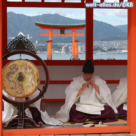 Shinto-Priester im Itsukushima-Schrein vor den Torii von Miyajima 